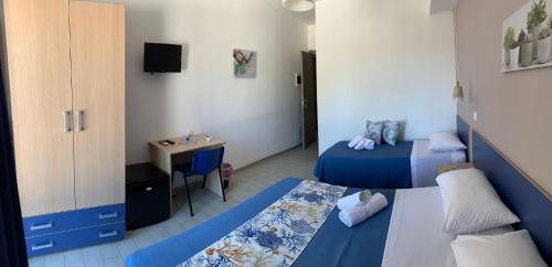 um pequeno quarto com 2 camas e um lavatório em B&B Giostemar - Playa Grande em Scicli