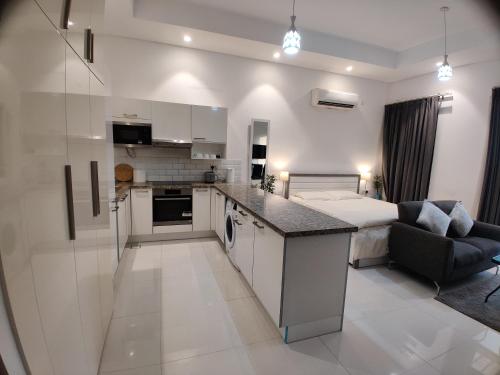 a kitchen and living room with a bed in a room at Hawana Salalah Laguna Studio in Salalah