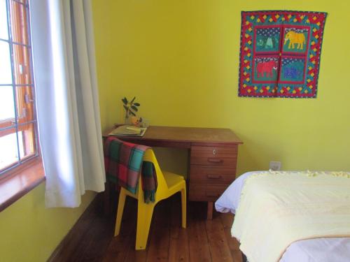 1 dormitorio con escritorio, silla y cama en Victorian Woodstock, en Ciudad del Cabo