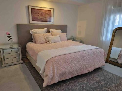 a bedroom with a large bed and a mirror at Charming 4 Bedroom Waterfront Home W/ Pool Near Casino in Gold Coast