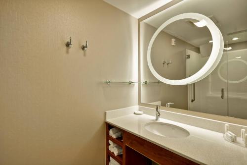 a bathroom with a sink and a large mirror at SpringHill Suites Tallahassee Central in Tallahassee
