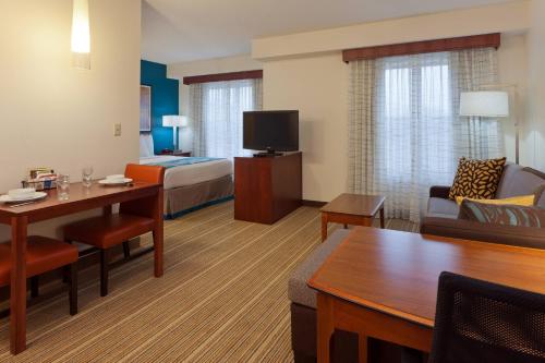 a hotel room with a bed and a living room at Residence Inn Indianapolis Carmel in Carmel