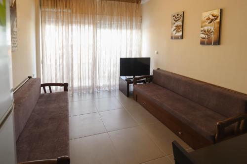 a waiting room with a couch and a television at Indigo luxury apartments in Olympiaki Akti
