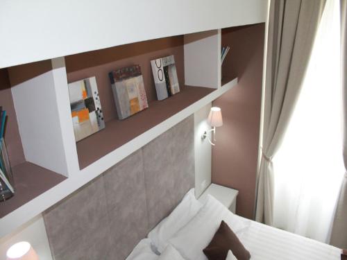 mały pokój z łóżkiem i lustrem w obiekcie Elenoire Rooms & Suite w Rzymie