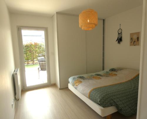 1 dormitorio con 1 cama y puerta corredera de cristal en Ground floor close to Geneva en Ornex