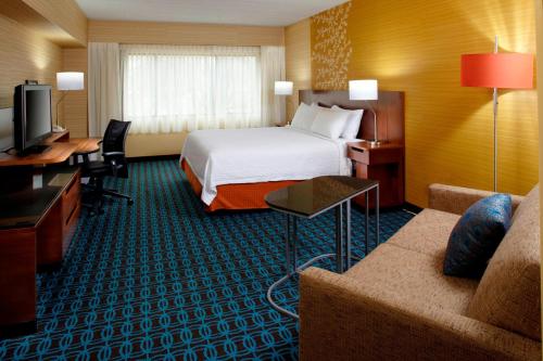 a hotel room with a bed and a couch at Fairfield Inn & Suites Parsippany in Parsippany