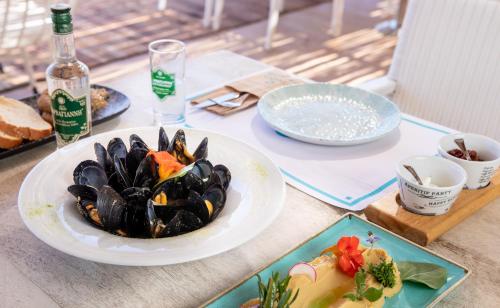 a table with plates of food and a plate of mussels at Yianna Caravel Suites "by Checkin" adults only in Amoudara Herakliou