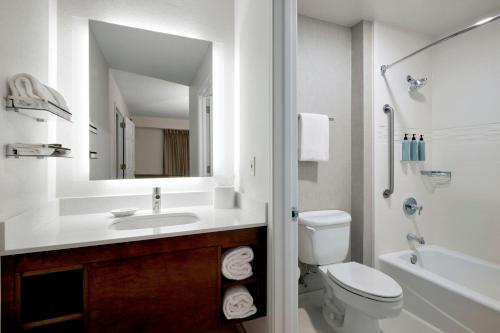 a bathroom with a sink and a toilet and a mirror at Residence Inn Eugene Springfield in Eugene