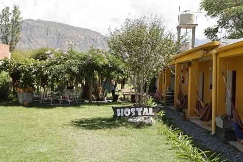 a yard with a hos rental sign in the grass at Hostel Lo de Chichi in Cafayate