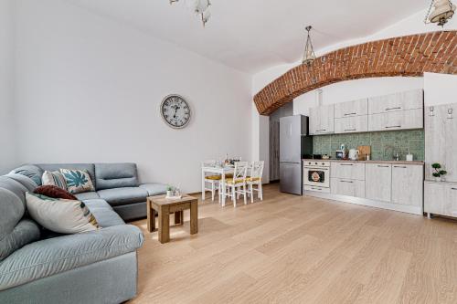 ein Wohnzimmer mit einem Sofa und einem Tisch sowie eine Küche in der Unterkunft ARI Central Apartment 1 in Arad