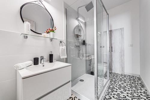 a white bathroom with a sink and a shower at ARI Central Apartment 1 in Arad