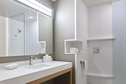 uma casa de banho com um lavatório, um espelho e um chuveiro em Courtyard Denver Aurora em Aurora