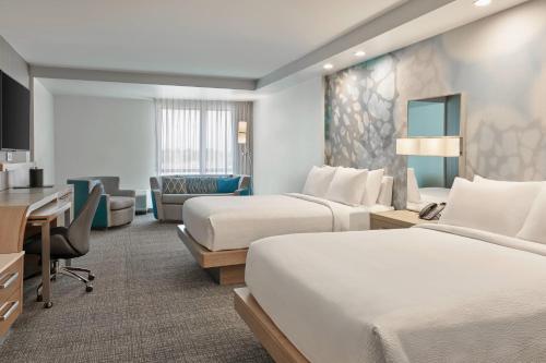 um quarto de hotel com duas camas e uma secretária em Courtyard Denver Aurora em Aurora