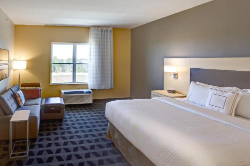 a hotel room with a large bed and a couch at TownePlace Suites by Marriott Wareham Buzzards Bay in Wareham