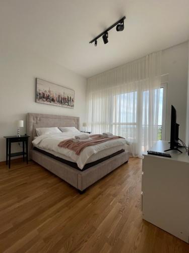 um quarto com uma cama e uma televisão em Apartman Bella Fruške Residences em Vrdnik