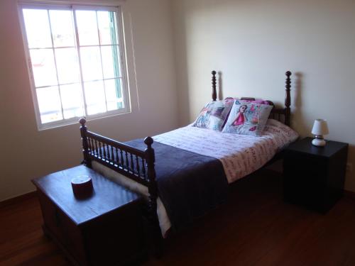 um quarto com uma cama e uma janela em Excelente T3 Duplex Funchal no Funchal