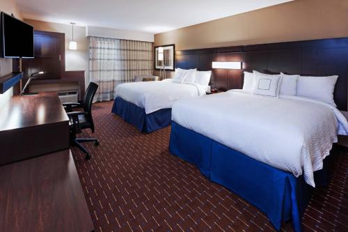 a hotel room with two beds and a desk at Courtyard by Marriott Odessa in Odessa