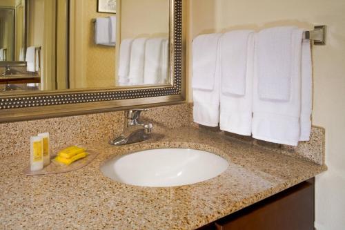 a bathroom with a sink and a mirror and towels at Residence Inn Aberdeen at Ripken Stadium in Aberdeen