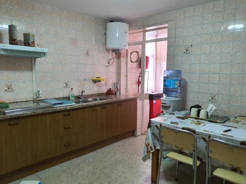 eine Küche mit einem Waschbecken und einem Tisch darin in der Unterkunft Casa Dora Duero in Zamora