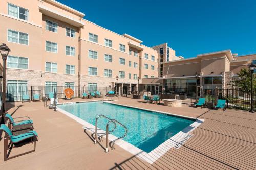 uma piscina num hotel com cadeiras e um edifício em Residence Inn by Marriott Austin - University Area em Austin