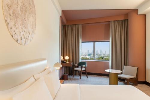 Habitación de hotel con cama y escritorio en Le Meridien Fairway, en Dubái