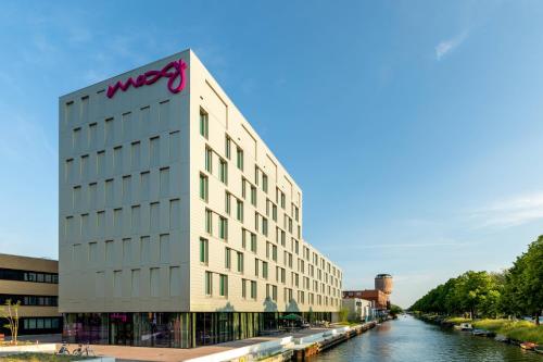 a building with the wpx logo on it next to a river at Moxy Utrecht in Utrecht