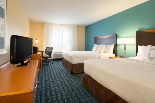 a hotel room with two beds and a flat screen tv at Fairfield Inn & Suites Bismarck South in Bismarck
