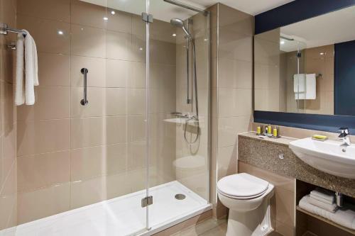 a bathroom with a shower and a toilet and a sink at Portsmouth Marriott Hotel in Portsmouth