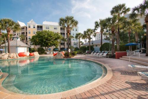 a swimming pool in a resort with palm trees at SpringHill Suites by Marriott Orlando Lake Buena Vista South in Kissimmee