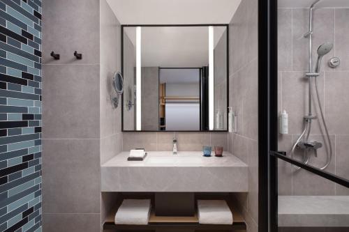 a bathroom with a sink and a mirror and a shower at Fairfield by Marriott Hangzhou Xihu District in Hangzhou
