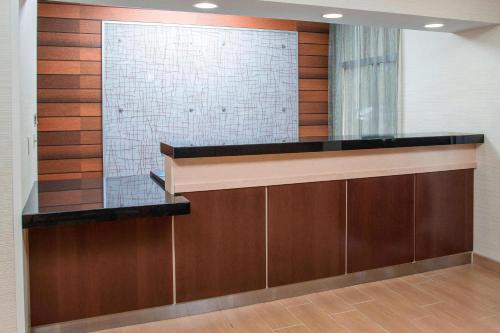 a lobby with a glass counter and a wall with wood at Fairfield Inn & Suites Chicago Tinley Park in Tinley Park