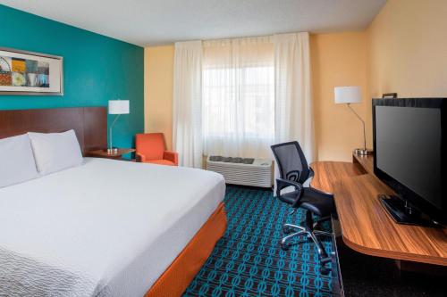 a hotel room with a bed and a desk with a television at Fairfield Inn & Suites Chicago Tinley Park in Tinley Park