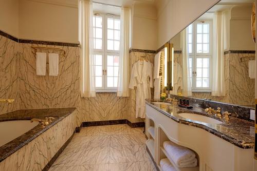 a bathroom with two sinks and a large mirror at Gewandhaus Dresden, Autograph Collection in Dresden