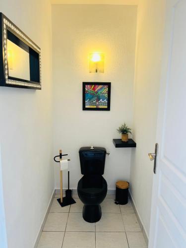 a bathroom with a black toilet in a room at PERLE DES ANTILLES in Oyster Pond