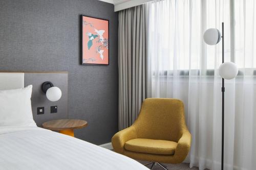 a hotel room with a bed and a chair at Cardiff Marriott Hotel in Cardiff