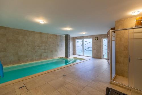 a bathroom with a swimming pool in the middle of a room at Casa Luxury Wellness Apartman By BLTN in Siófok