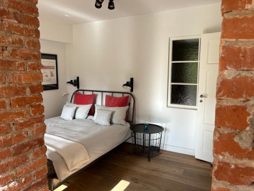 a bedroom with a bed with red pillows at Apartment im Geteviertel - citynah in Bremen
