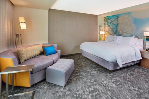 a hotel room with a bed and a couch at Courtyard by Marriott Rome in Rome