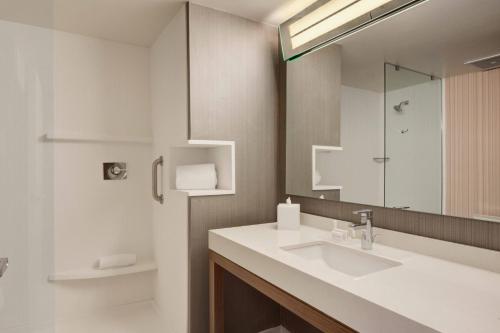 ein Bad mit einem Waschbecken und einem Spiegel in der Unterkunft Courtyard by Marriott Rome in Rome