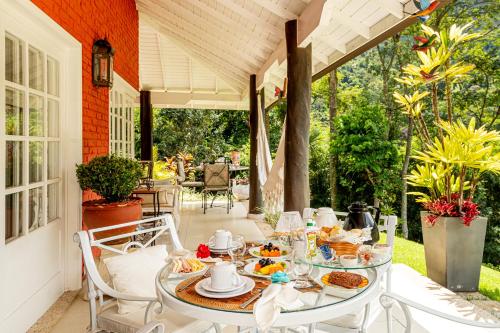 a table with plates of food on a patio at Su Paradise Villa Chalés e Suítes in Itaipava