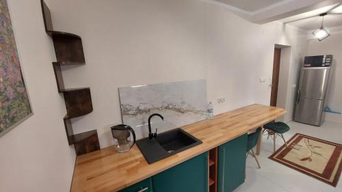 a kitchen with a sink and a wooden counter top at STUDIO przy WIEŻY in Otmuchów