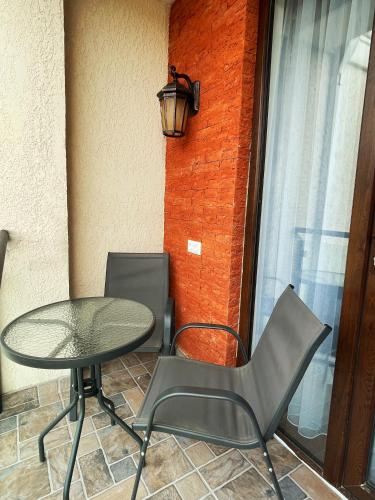 a patio with a table and chairs and a lamp at City Heart Luxury Apartment in Kutaisi