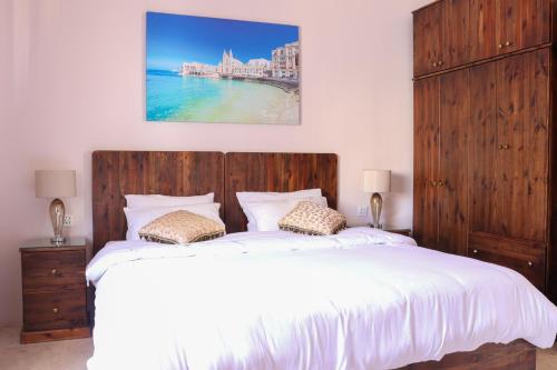 una camera con un grande letto con testiera in legno di Madonnina Homestay a San Giuliano