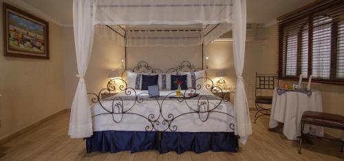 a bedroom with a bed with a canopy at Arcángel Puebla in Puebla