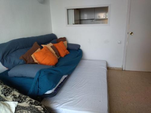 un divano blu con cuscini sopra di Apartamento con vistas al mar a Las Canteras