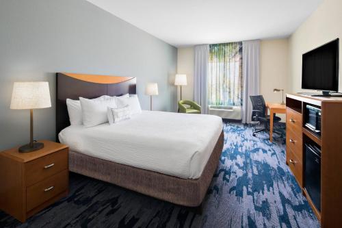 a hotel room with a bed and a flat screen tv at Fairfield Inn & Suites by Marriott Hobbs in Hobbs