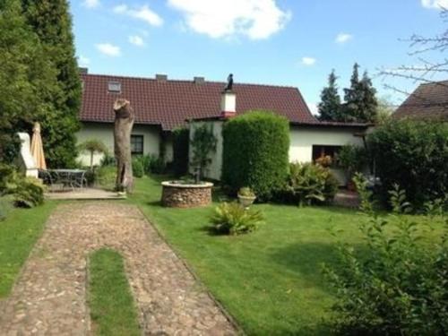 een huis met een tuin met een grasveld sidx sidx sidx bij Tolles Appartement in Gehren mit Garten, Terrasse und Grill in Heideblick