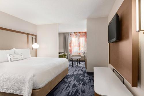 a hotel room with a bed and a flat screen tv at Fairfield Inn Erie Millcreek Mall in Erie