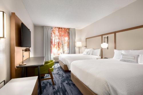 a hotel room with two beds and a desk and a window at Fairfield Inn Erie Millcreek Mall in Erie