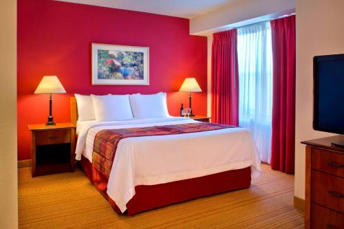 a bedroom with a large bed with red walls at Residence Inn Boston Andover in Andover